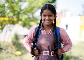Cheerful Indian schoolgirl in uniform smiling outdoors in Lucknow, India.